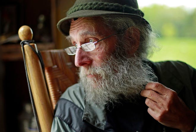 FILE - In May 23, 2014, file photo, Burt Shavitz pauses during an interview to watch a litter of fox kits play near his camp in Parkman, Maine. Shavitz, a former beekeeper, is the Burt behind Burt's Bees. A spokeswoman for Burt's Bees said Shavtiz died Sunday, July 5, 2015, at his home in rural Maine. He was 80. (AP Photo/Robert F. Bukaty, File)