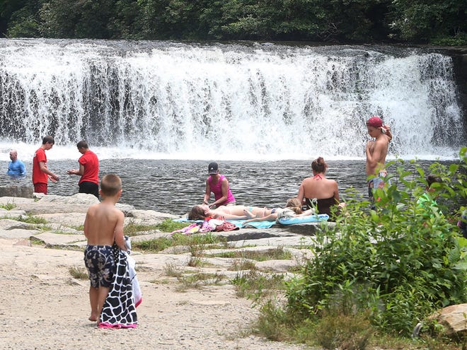 Visitors enjoy an afternoon at Hooker Falls in DuPont State Recreational Forest on Wednesday, the same location as parts of the movie "Max" was filmed.