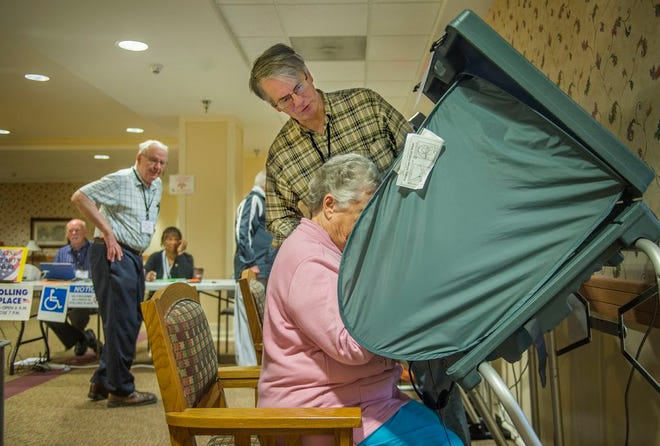 Election judge John Alms advises Doris Hoerdeman Tuesday on the mechanics of electronic voting at the polling place in Lutheran Hillside Village for the special primary election to select candidates to replace resigned U. S. Rep. Aaron Schock in the 18th Congressional District.