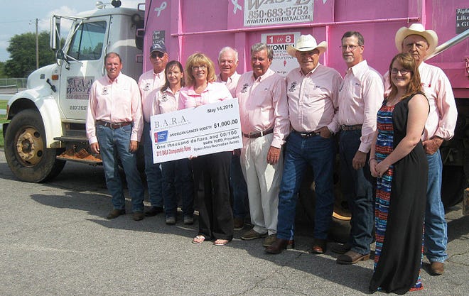 Making Strides Against Breast Cancer’s Donna Fought, holding check, and Kyla Pugh, right front, accept a $1,000 donation from Baker Pro Rodeo organizers Mark Stalnaker, Ernie Brewbaker, Edith Elder, Russell Moorman, Joe Fisher, Bill Graham, President Mark Todd and Jim Silcox.