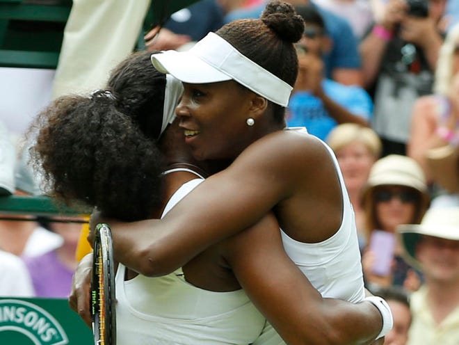 Serena Williams of the United States, left, hugs her sister Venus Williams of the United States after winning their singles match, at the All England Lawn Tennis Championships in Wimbledon, London, Monday July 6, 2015. Serena Williams won 6-4, 6-3.