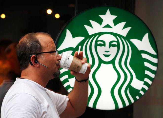 Associated Press file photoA man drinks a Starbucks coffee in New York in 2013. Starbucks says it's hiking prices again starting today, with the increases ranging from 5 to 20 cents for most affected drinks.