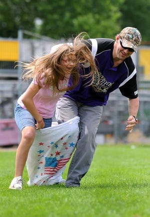 Nathan Frye of Scio and his niece Alessia Henry, 11, of Dennison, give it their all during the sack races at the First Town Days Festival Friday at Tuscora Park in New Philadelphia.