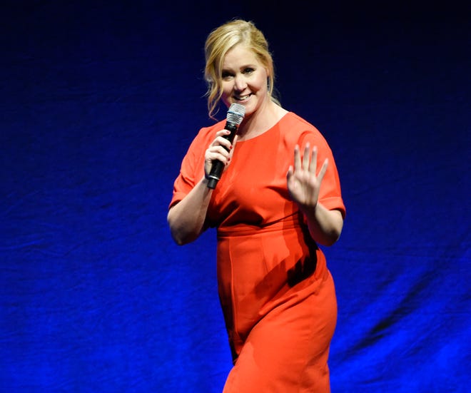 In this April 23, 2015, file photo, Amy Schumer, the writer and star of the upcoming film "Trainwreck," waves to the audience during the Universal Pictures presentation at CinemaCon 2015 at Caesars Palace in Las Vegas. Schumer, Queen Latifah and Sara Evans headlined the first annual 4th of July Freedom Festival at the Intrepid Sea, Air & Space Museum in New York City on Saturday, July 4, 2015. (Photo by Chris Pizzello/Invision/AP, File)