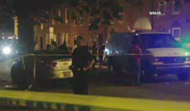 In this image taken from video, police investigate the scene of a shooting, Tuesday, July 7, 2015, in Baltimore. Baltimore police say four people have been shot, three fatally, near the University of Maryland, Baltimore, campus. (WMAR via AP)