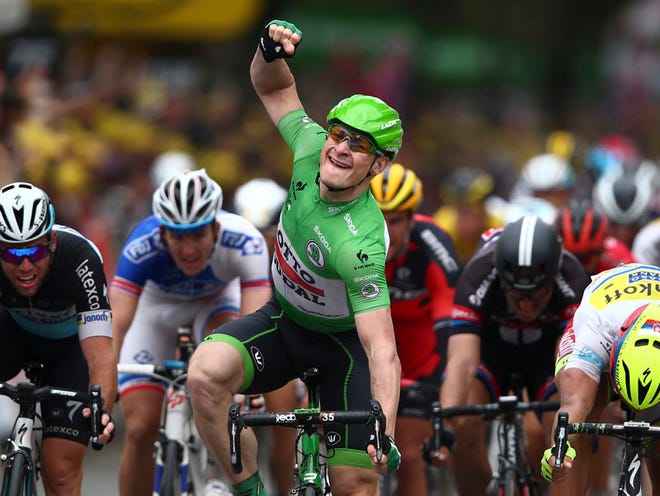 Germany's Andre Greipel celebrates as he crosses the finish line ahead of Britain's sprinter Mark Cavendish, left, and Peter Sagan of Slovakia, right, to win the fifth stage of the Tour de France cycling race over 189.5 kilometers (117.8 miles) with start in Arras and finish in Amiens, France, Wednesday, July 8, 2015.