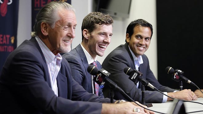 Miami Heat's Goran Dragic, center, laughs at a comment by Miami Heat president Pat Riley, left, as head coach Erik Spoelstra, right, smiles during a news conference, Thursday, July 9, 2015, in Miami. Goran Dragic has signed his five-year deal with the Miami Heat. (AP Photo/Alan Diaz)