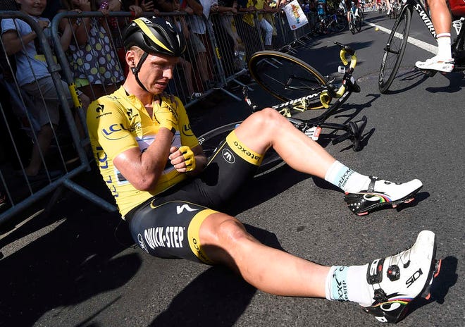 Germany's Tony Martin, wearing the overall leader's yellow jersey, holds his broken collar bone after crashing in the last portion of the sixth stage of the Tour de France on Thursday in Le Havre, France. (AP Photo/Eric Feferberg)