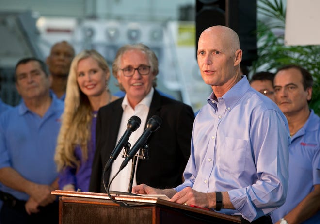 Florida Gov. Rick Scott, foreground, speaks during a news conference in Hollywood on Tuesday.
