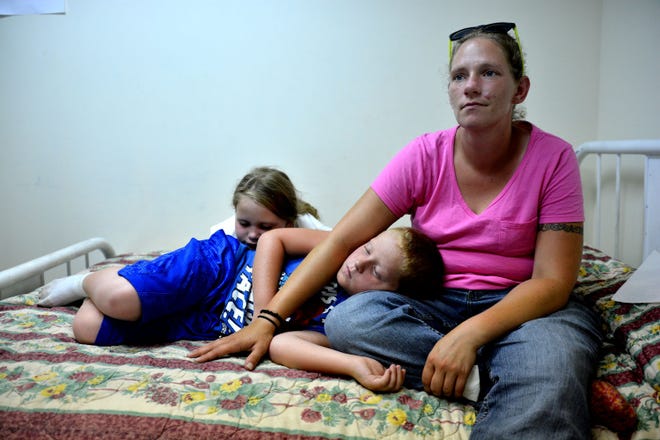 Naomi Driesel sits with her two children, Damion, 9, and Tesla, 8, on NOEL Lodge’s reopening day Friday. Driesel just got a job and is relieved she has a place for her children and herself until she can afford a place of her own.