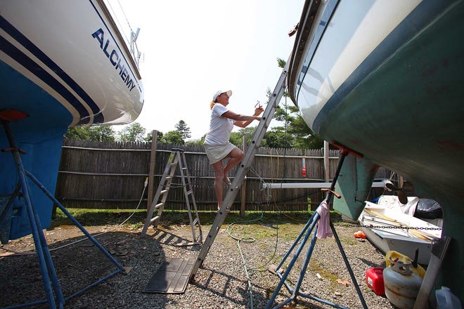 Donna Lange climbs her boat, Inspired Insanity, at Bristol Marina. After she was involved in a fatal car accident and struggled to move on, Lange found the peace of mind she was craving in sailing. The Providence Journal/Glenn Osmundson