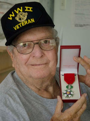 PETER.WILLOTT@STAUGUSTINE.COMWorld War II veteran Emmett L. "Jack" Worley poses with his French Legion of Honor medal in the kitchen of his home in St. Augustine on Friday, July 9, 2015. Worley was one of 28 Floridians awarded the medal last week by the French government for his service in the U.S. Army in France during World War II.