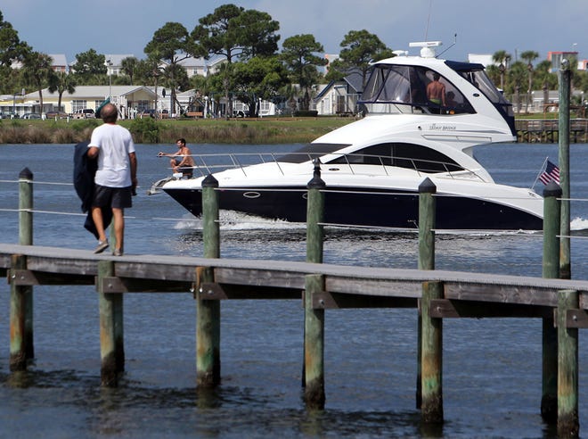 A boat cruises by a dock July 8 at the Finisterre community in Grand Lagoon in Panama City Beach.