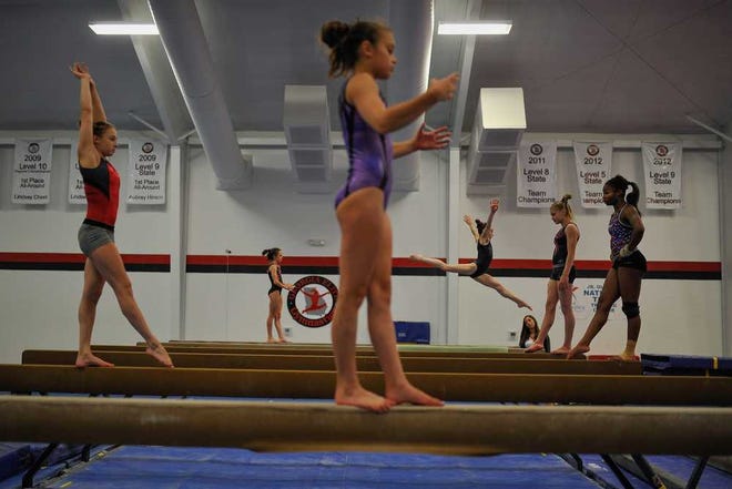 Gymnasts practice on the balance beam on Thursday, July 2, 2015 at Georgia Elite Gymnastics in Watkinsville, Ga.