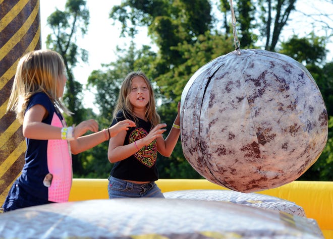 Katie McKerchar (left), 7, and her sister Emily, 10, play with a wrecking ball during the annual First Fourth at Newtown Middle School on Saturday July 11, 2015.