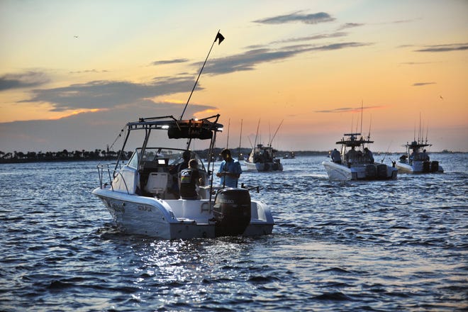 Boats head out the mouth of the St. Johns River at dawn during the start of the Greater Jacksonville, Kingfish Tournament Friday, July 25, 2014 in Mayport.