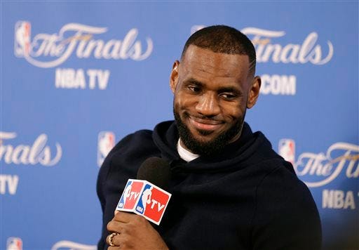 FILE - In this June 7, 2015, file photo, Cleveland Cavaliers forward LeBron James smiles during a news conference after Game 2 of basketball's NBA Finals in Oakland, Calif. Two people familiar with the negotiations say LeBron James has agreed to a one-year, $23 million contract with the Cavaliers for next season. The deal includes a player option for 2016-17. The people spoke to The Associated Press on condition of anonymity Thursday because the contract has not been signed. James has informed the team he will return. AP Photo/Ben Margot, File