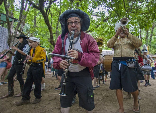 Band members play as they walk in the opening day parade that goes through the Oregon Country Fair in Veneta. (Mary Jane Schulte/The Register-Guard)