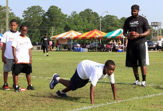 Former Havelock standout and current NFL linebacker Bruce Carter watches players go through drills at his youth football camp on Saturday. More than 100 children attended the camp.