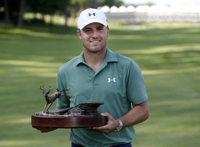 Jordan Spieth poses with the John Deere Classic trophy after winning the tournament by defeating Tom Gillis on the second playoff hole Sunday, July 12, 2015, in Silvis, Ill.