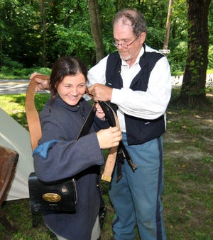 Robert Heulings, of the 12th New Jersey Volunteer Infantry, helps Francesca Hinke, of Moorestown, try on his jacket during Civil War demonstration at Country Day at Kirby’s Mill in Medford on Sunday, July 12, 2015.