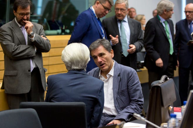 Greek Finance Minister Euclid Tsakalotos, center right, speaks with Managing Director of the International Monetary Fund Christine Lagarde, center left, during a round table meeting of eurogroup finance ministers at the EU Lex building in Brussels on Sunday, July 12, 2015. Greece has another chance Sunday to convince skeptical European creditors that it can be trusted to enact wide-ranging economic reforms which would safeguard its future in the common euro currency. (AP Photo/Virginia Mayo)