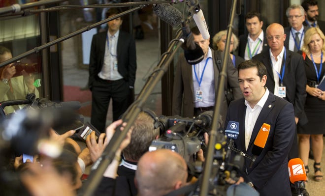 Greek Prime Minister Alexis Tsipras, right, speaks with the media after an emergency summit of eurozone heads of state or government in Brussels on Tuesday, July 7, 2015. Frustrated and angered eurozone leaders gave Greek Prime Minister Alexis Tsipras a last-minute chance on Tuesday to finally come up with a viable proposal on how to save his country from financial ruin. (AP Photo/Michel Euler)