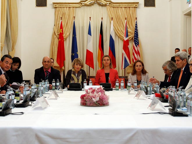German Foreign Minister Frank-Walter Steinmeier, left, French Foreign Minister Laurent Fabius, 2nd left, Chinese Foreign Minister Wang Yi, 3rd left, European Union foreign policy chief Federica Mogherini, centre in red, U.S. Secretary of State John Kerry, 4th right, and Russian Foreign Minister Sergei Lavrov, right, meet at a hotel in Vienna Monday July 13, 2015. Negotiators at the Iran nuclear talks plan to announce Monday that they've reached a historic deal capping nearly a decade of diplomacy that would curb the country's atomic program in return for sanctions relief, two diplomats told The Associated Press on Sunday. Other attendees at meeting not Identified.