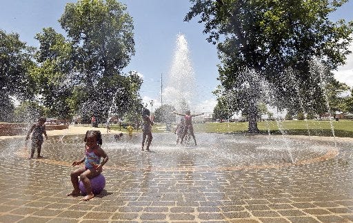 Children from One Accords Kingdom Kids Learning Center Summer Camp, as well as others from the community, cool off from the summer heat as they play in the fountain at Annette M. Shelby Park on the corner of 15th Street and Queen City Boulevard Friday, June 19, 2015. Staff Photo | Michelle Lepianka Carter