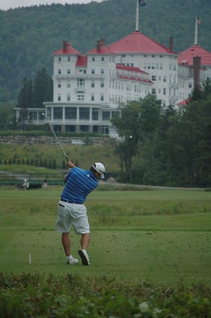 Brett Wilson of the Golf Club of New England tees off on the 18th hole with the Omni Mt. Washington Hotel in the background at the 112th New Hampshire Amateur golf championship in Bretton Woods on Tuesday.