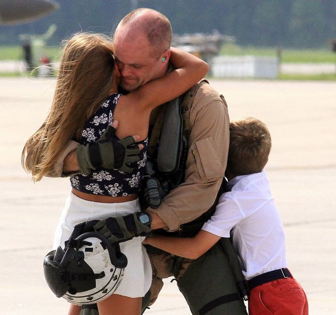 Maj. James Tanis gets hugs from daughter Megan, 11, and son Cody, 9, upon his return to Cherry Point on Tuesday. He had been deployed with the 24th Marine Expeditionary Unit for about eight months.