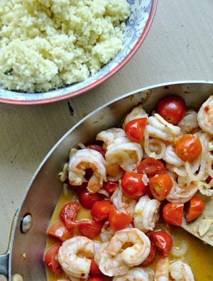Garlicky shrimp are paired with sweet cherry tomatoes in this light summer dish. (Gretchen McKay/Pittsburgh Post-Gazette/TNS)