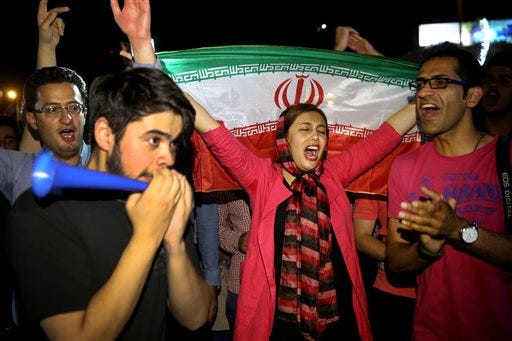 An Iranian woman holds up an Iranian flag as people celebrate a landmark nuclear deal, in Tehran, Iran, Tuesday, July 14, 2015. Overcoming decades of hostility, Iran, the United States, and five other world powers struck a historic accord Tuesday to check Tehran's nuclear efforts short of building a bomb. The agreement could give Iran access to billions in frozen assets and oil revenue, stave off more U.S. military action in the Middle East and reshape the tumultuous region. (AP Photo/Ebrahim Noroozi)