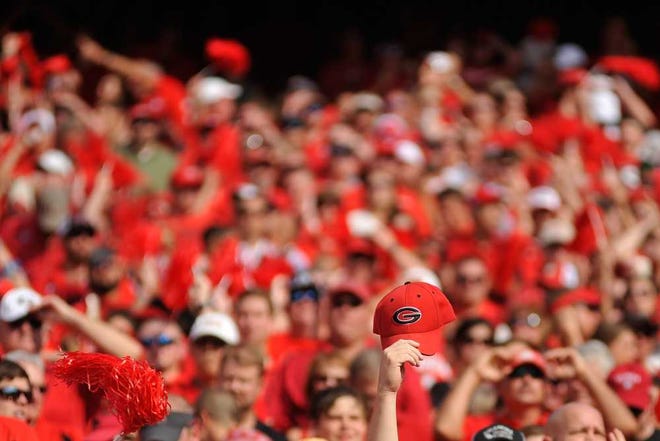 A fan holds a Georgia hat in the air during the NCAA college football game between Georgia and Clemson on Saturday, August 30, 2014, in Athens, Ga. (AJ Reynolds/Staff, @ajreynoldsphoto)