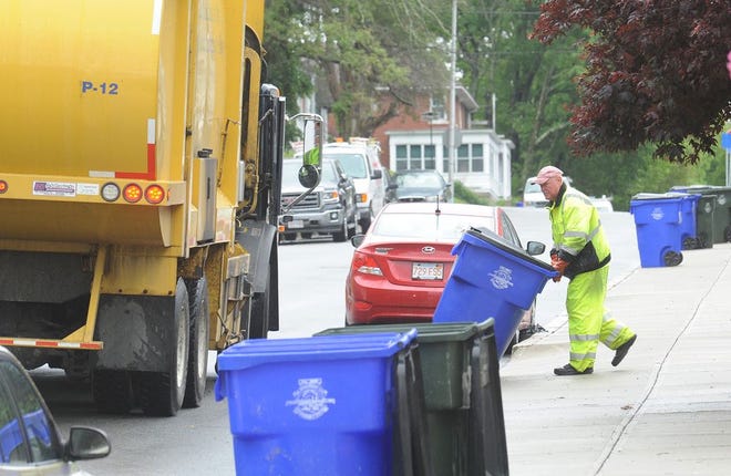 Department of Community Maintenance worker Bob Kelly empties recycle bins on June Street.
