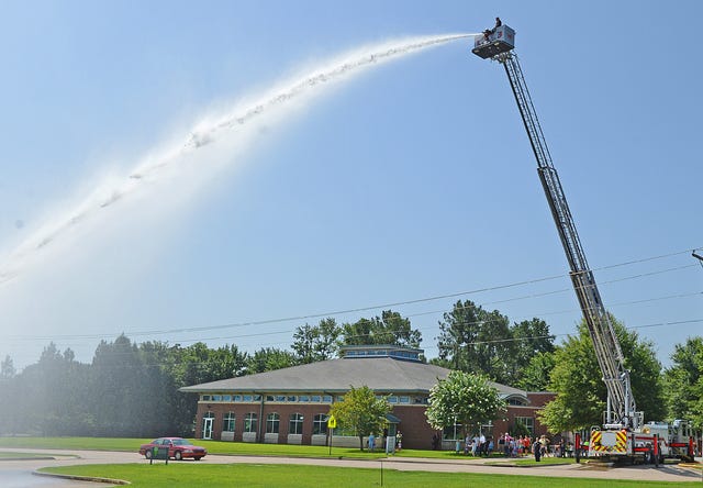 BRIAN D. SANDERFORD • TIMES RECORD Driver Max Garrett with the Fort Smith Fire Department sprays water from atop Ladder 3 as guest watch from below at the Dallas Branch of the Fort Smith Public Library on Wednesday, July 15, 2015. Representatives from the FSFD talked about their jobs and demonstrated equipment including Gracie the bomb squad robot. The program is part of the library’s Hometown Heroes Storytime. 
 BRIAN D. SANDERFORD • TIMES RECORD Gracie the Fort Smith Fire Department Bomb Squad robot moves around the Dallas Branch of the Fort Smith Public Library on Wednesday, July 15, 2015. Representatives from the FSFD talked about their jobs and demonstrated equipment including spraying water from Ladder 3. The program is part of the library’s Hometown Heroes Storytime.