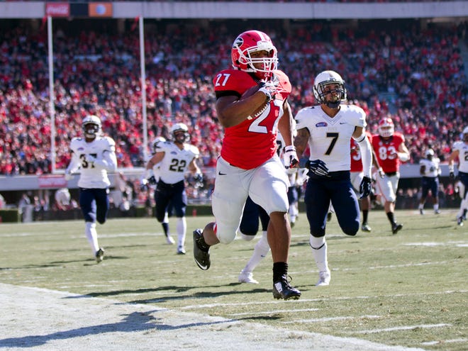 Georgia running back Nick Chubb (27) runs away from Charleston Southern defensive back Troy McGowens (7) as he scores a touchdown in the first half of an NCAA college football game, Saturday, Nov. 22, 2014, in Athens, Ga. (AP Photo/John Bazemore)