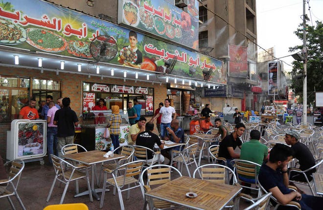 Iraqis hang out at a cafe in central Baghdad, Iraq, Thursday, July 16, 2015. The government declared Thursday an official holiday due to scorching temperatures. Health authorities have warned people not to expose themselves to the sun, with hospitals already receiving an overwhelming number of heat-related cases.