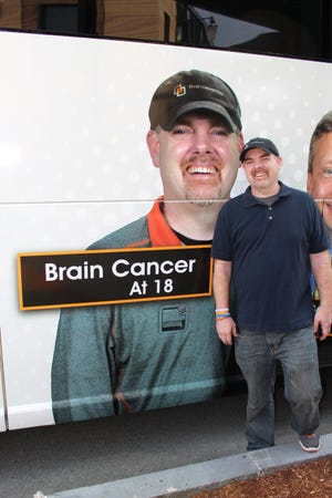 Cancer survivor Dave McGrath of Worcester stands by his picture on a Peter Pan bus wrap for the 15-40 Connection urging early cancer detection. Submitted Photo