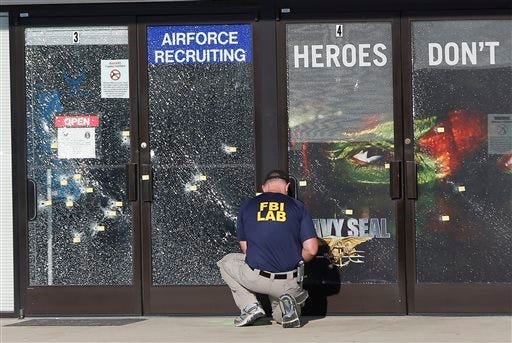 An FBI investigator investigates the scene of a shooting outside a military recruiting center on Friday, July 17, 2015, in Chattanooga, Tenn. Muhammad Youssef Abdulazeez of Hixson, Tenn., attacked two military facilities on Thursday, in a shooting rampage that killed four Marines. (AP Photo/John Bazemore)