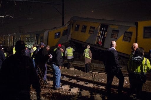Emergency workers gather at the scene of a train collision at the Booysens train station near Johannesburg Friday July 17, 2015. A commuter train crashed into another passenger train during rush hour Friday in South Africa's largest city injuring more than 300 people, an emergency services spokeswoman said. (AP Photo/Jacques Nelles)