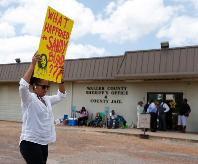 Brandi Holmes, of Houston, carries a sign as she protests in front of the Waller County Sheriff's Office and county jail on Monday, July 20, 2015, in Hempstead, Texas. Authorities said Bland hanged herself in the jail three days after being pulled over by police for a traffic violation and then arrested for allegedly kicking an officer during the stop. Bland's family is ordering an independent autopsy, lawyers said. (Karen Warren/Houston Chronicle via AP) MANDATORY CREDIT