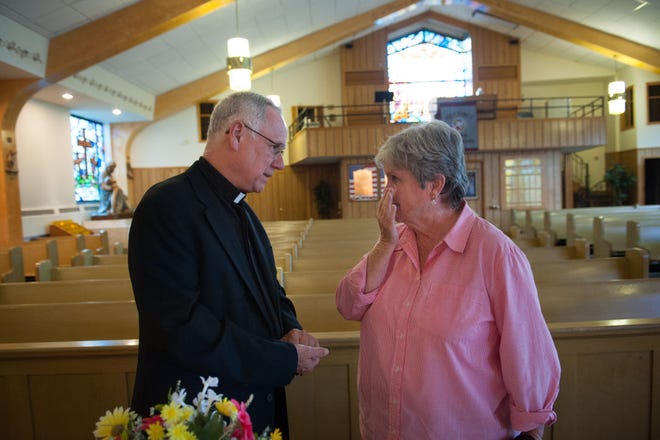 Louise Horan, of Levittown, wipes away tears while talking with Monsignor Michael McCormac, who has overseen the merging of the Saint Joseph the Worker and Saint Francis Cabrini parishes over the last year. Horan attended a farewell open house at Saint Joseph in Levittown on Tuesday evening, July 21, 2015.