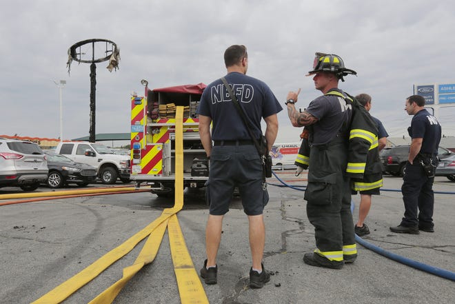 New Bedford firefighters inspect the cause for the fire that destroyed the Ashley Ford sign on Mt. Pleasant Street in New Bedford.  PHOTO PETER PEREIRA/The Standard-Times