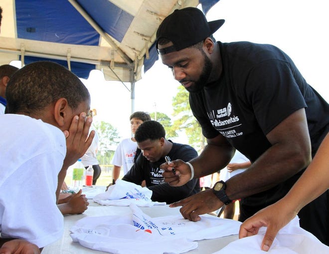 Havelock native and Tampa Bay linebacker Bruce Carter signs autographs at his football camp on July 11. Carter is getting ready to report to Tampa Bay's training camp on Aug. 1.
