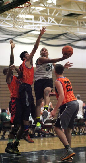 Cornwall's Jason Bailey (31) is met by three S.S. Seward defenders as he drives to the hoop during a summer league game Monday at SUNY Orange. William Montgomery/Times Herald-Record