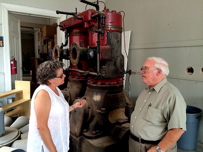 Carol Hill chats with David Lang, co-chairman of the subcommittee overseeing renovation of the old fire station in Bordentown City. Behind them is an antique boiler.