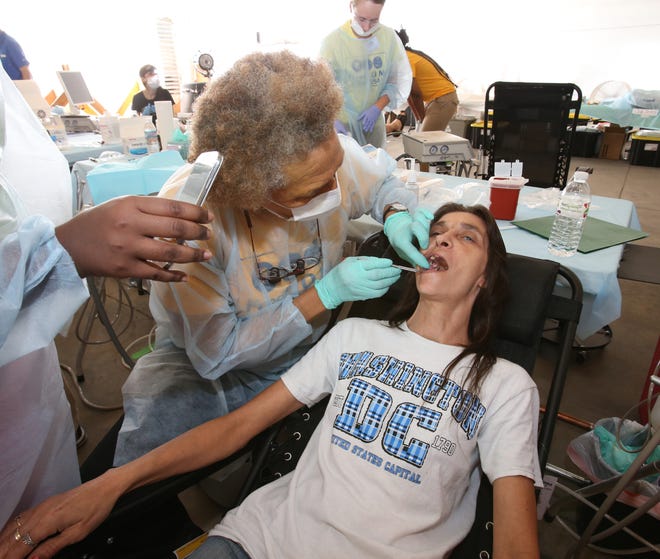 Tracy Strawn, of Belleview, receives free dental treatment from Dr. Monica Slack Haynes during the FreeD.O.M. Clinic USA at the old location of the Ocala Entertainment Complex on Southwest 17th Avenue in Ocala on Wednesday. More than 1,000 people came to the clinic to get free dental, optical and medical services.