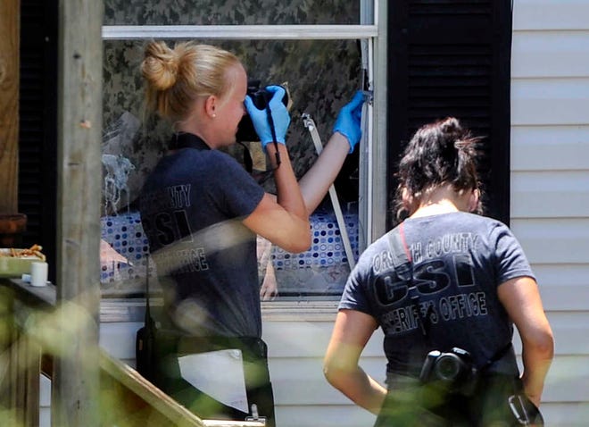 Law enforcement investigate the scene of a shooting at a home in Suwanee, Ga., Wednesday, July 22, 2015. A gunman killed a woman and two children and wounded another man before killing himself inside the suburban Atlanta home early Wednesday, Forsyth County Sheriff Duane Piper said. (AP Photo/John Amis)