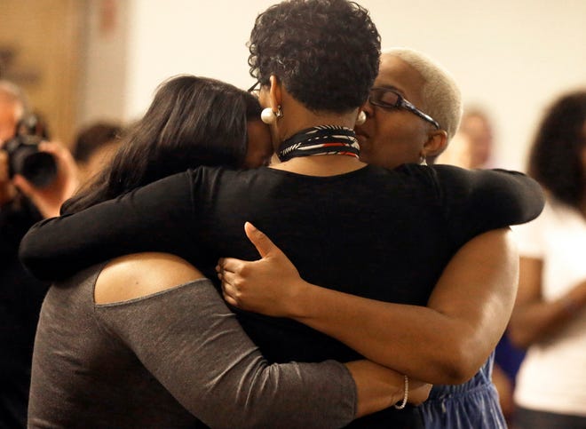 Geneva Reed-Veel, center, hugs family members at a memorial service for her daughter Sandra Bland at Prairie View A&M University, Tuesday, July 21, 2015, in Prairie View, Texas. A newly released dashcam video documents how a routine traffic stop escalated into a shouting confrontation between a Texas state trooper and Bland, which led to her arrest. Bland was found hanging in her jail cell three days after the incident. (AP Photo/Pat Sullivan)